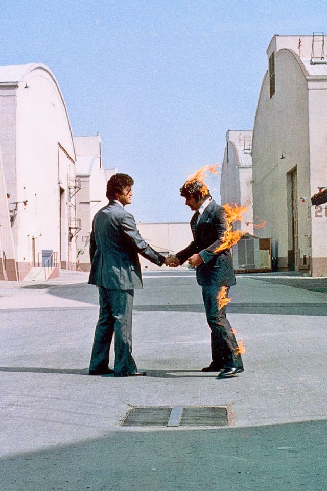 The photo from the cover of Pink Floyd's album "Wish You Were Here", showing two men shaking hands, one of whom is on fire.