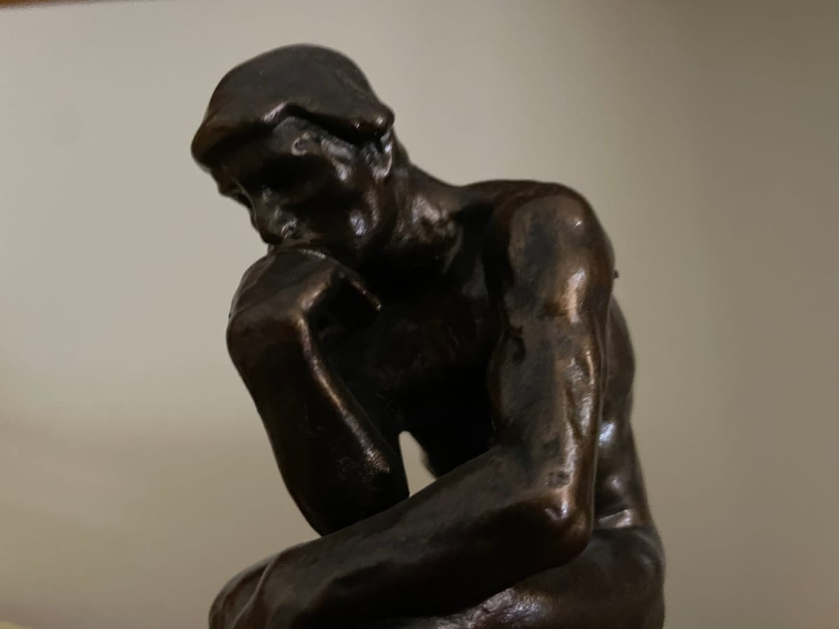 A small bronze facsimile of Rodin's "Thinker".  