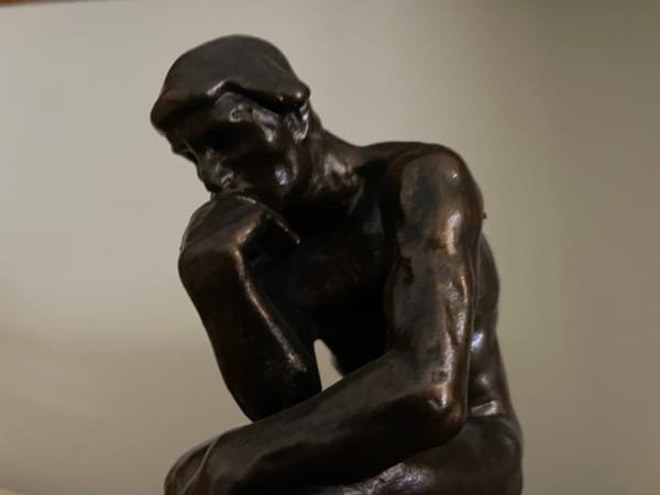 A small bronze facsimile of Rodin's "Thinker".  